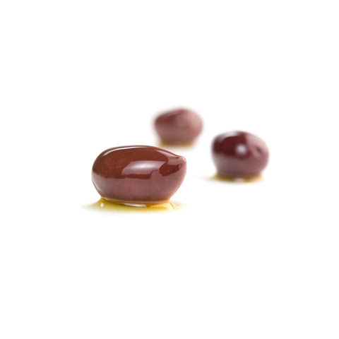 Pitted calamata olives on a white background