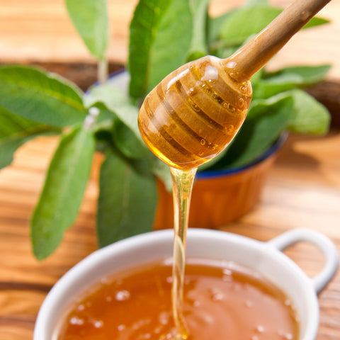 Honey dripping off a wooden spoon