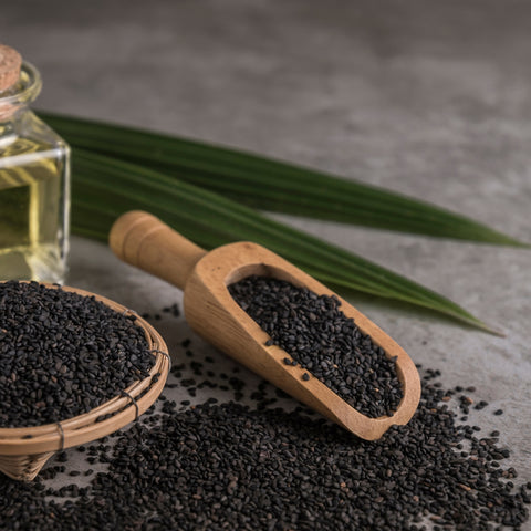 organic black seeds in a wooden scoop and basket 