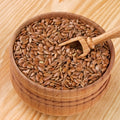 Wooden bowl filled with organic brown flax seeds on a wooden surface
