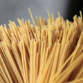 Close-up of uncooked organic brown rice spaghetti noodles with a blurred background