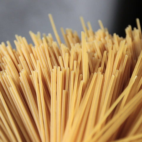 Close-up of uncooked organic brown rice spaghetti noodles with a blurred background