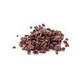 Pile of organic cacao nibs on a white background