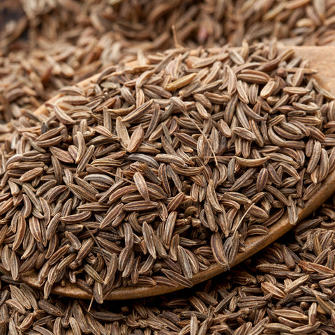 Close-up of organic caraway seeds with a wooden spoon