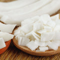 Organic wide coconut slices on a wooden plate and textured surface