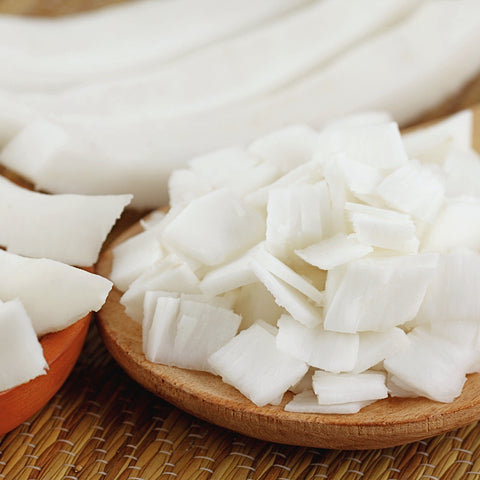 Organic wide coconut slices on a wooden plate and textured surface