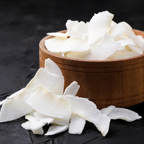 Organic wide coconut slices on a wooden plate and textured surface