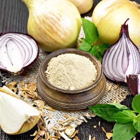 Bowl of organic onion powder next to onions