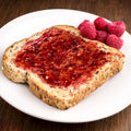 Organic raspberry fruit spread on a piece of bread