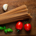 Organic whole wheat pasta on a table with tomatoes 